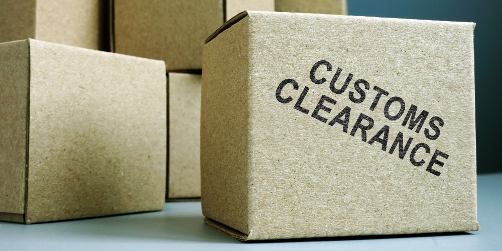 Stack of shipping boxes with one labeled “Customs Clearance” – Sinford’s expert customs solutions