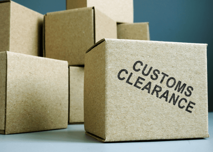 Shipping boxes and cargo packages with customs clearance documentation, representing import and export compliance services.