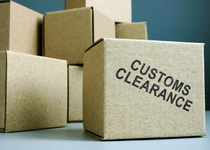 Shipping boxes and cargo packages with customs clearance documentation, representing import and export compliance services.