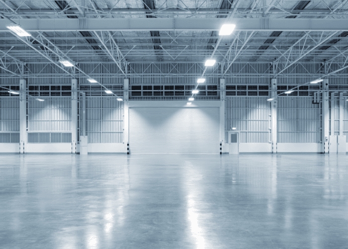Warehouse receiving and dispatch loading doors with trucks positioned for loading and unloading goods, representing logistics consulting services.
