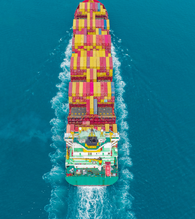 Container cargo ship transporting freight across international shipping routes in clear blue ocean waters